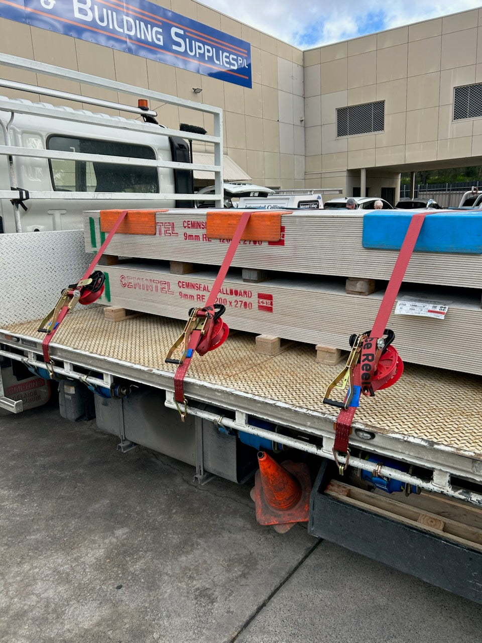 Race Reels ratchet strap systems securing commercial sheet load on a flat-bed truck at Burns Ceilings and Building Supplies.